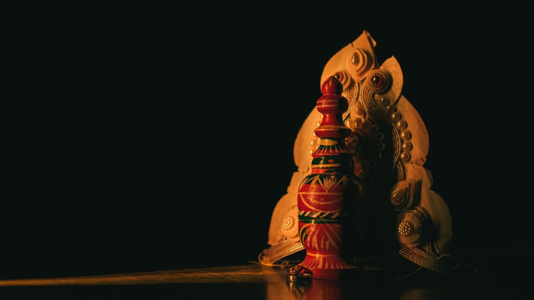 a red and white vase sitting on top of a table
