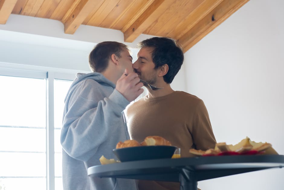 A loving couple shares a tender kiss during breakfast at home.
