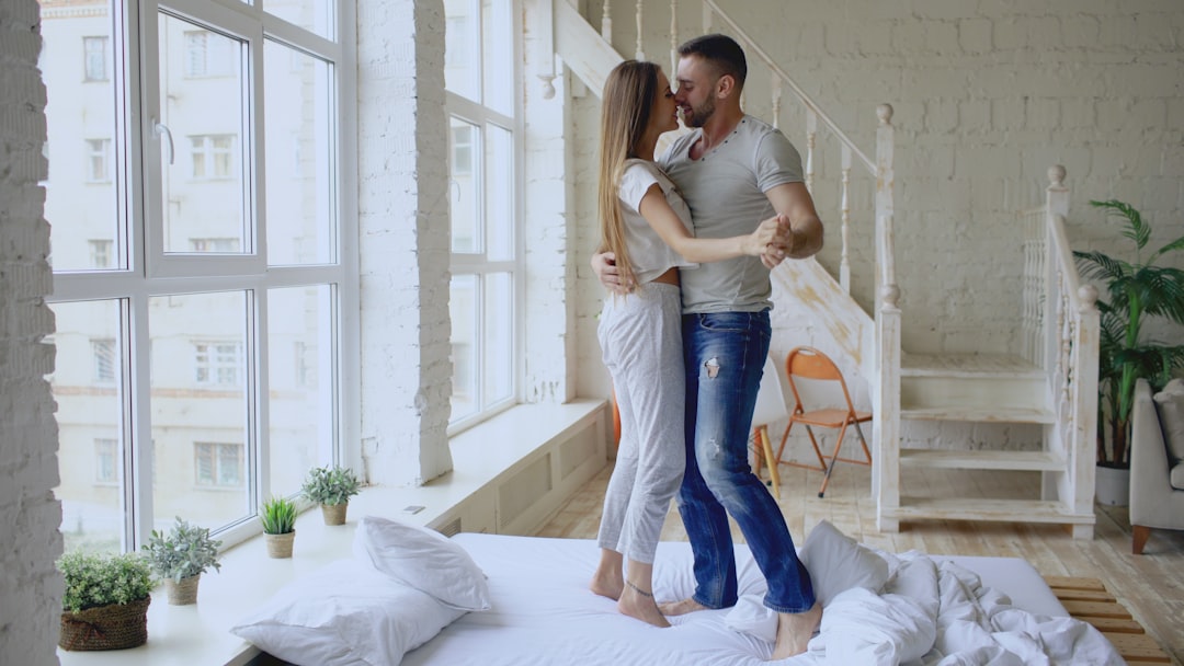 Couple dancing romantically on a bed