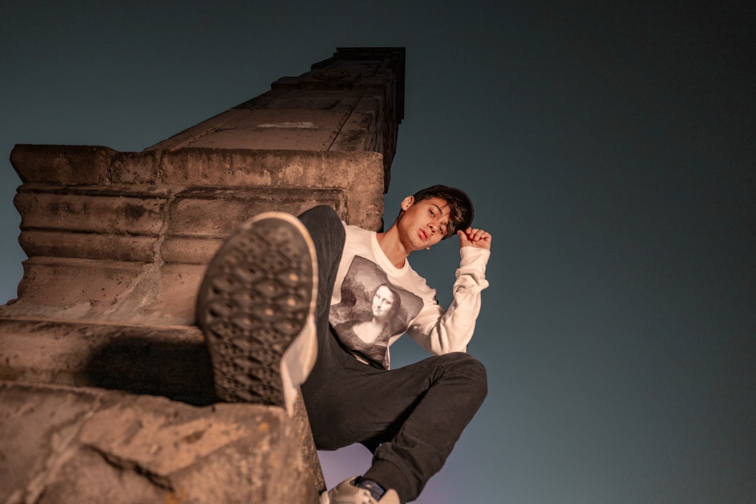 man sitting on brown concrete tower