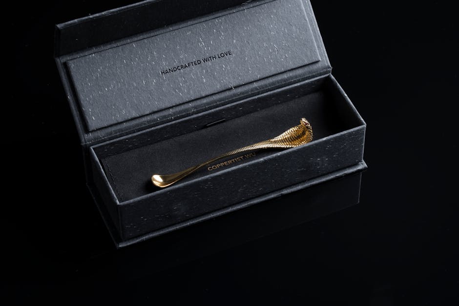 Close-up of a handcrafted golden snake-themed spoon in a black luxury box.