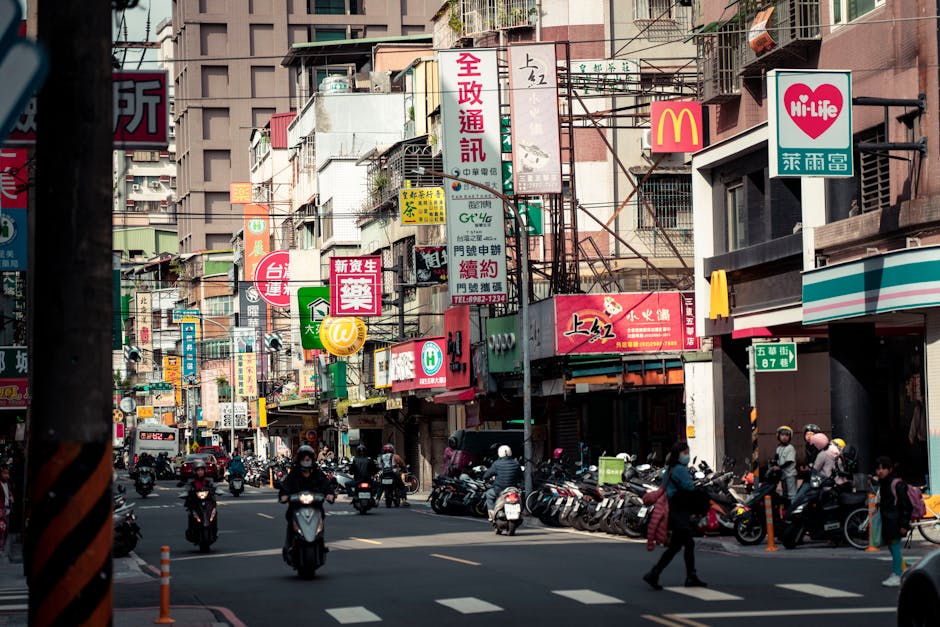 Busy urban street in New Taipei City showcasing local shops, signs, and traffic.