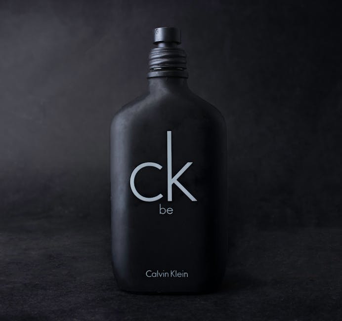 Close-up of Calvin Klein CK Be perfume bottle with dark background.