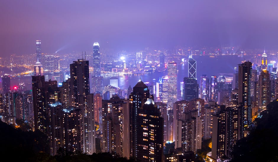 Stunning night view of Hong Kong skyline with illuminated skyscrapers and city lights.