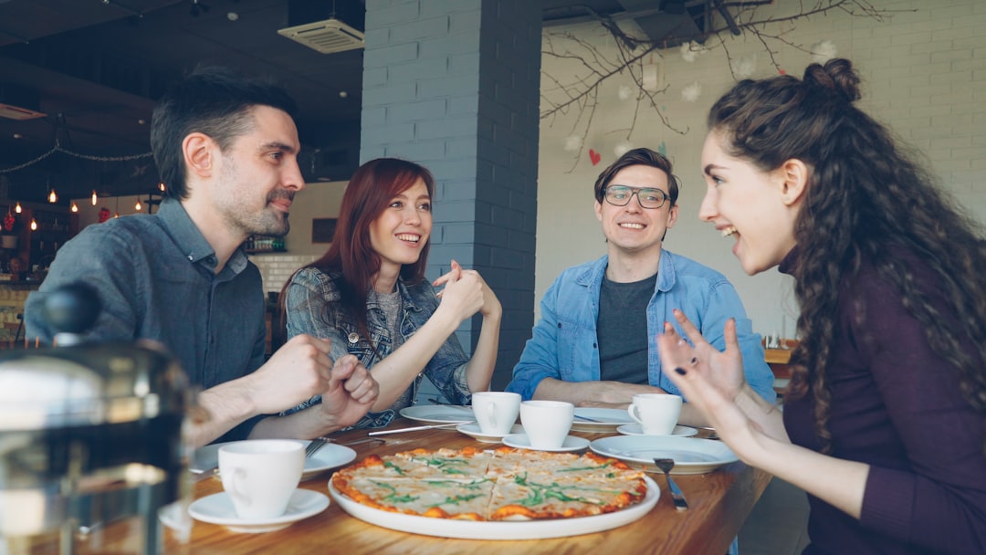Friends enjoy pizza and conversation at a restaurant.