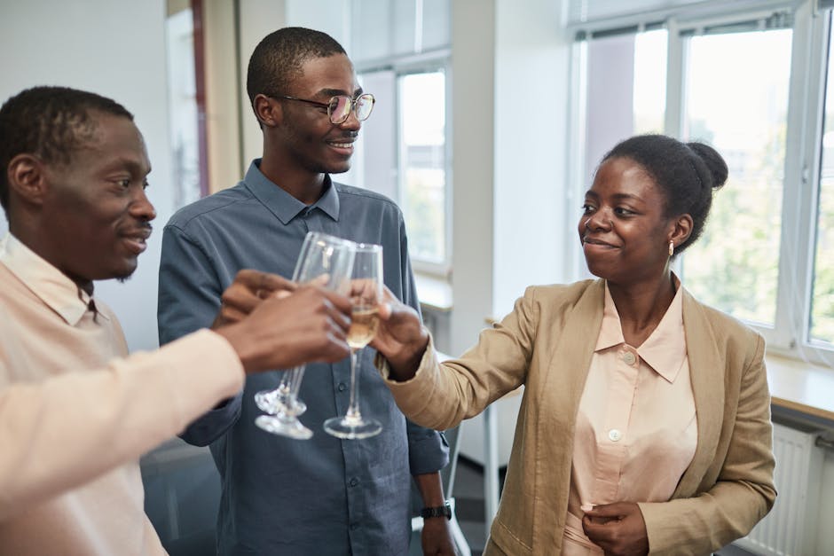 Three adults celebrate with a toast indoors, expressing joy and camaraderie.