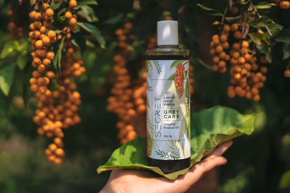 Close-up of grey care oil held in hand with botanical backdrop in TN, India.