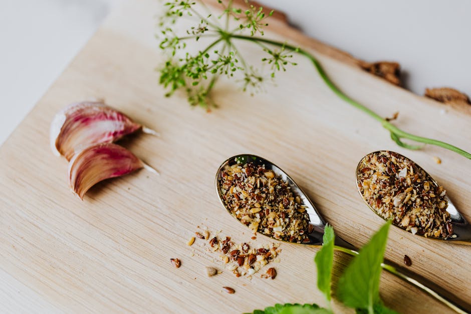 A close-up of herbs and spices on a wooden board with garlic and fresh greens.