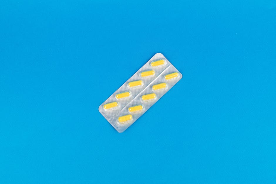 Pack of yellow capsules on a vibrant blue background symbolizing modern medicine.