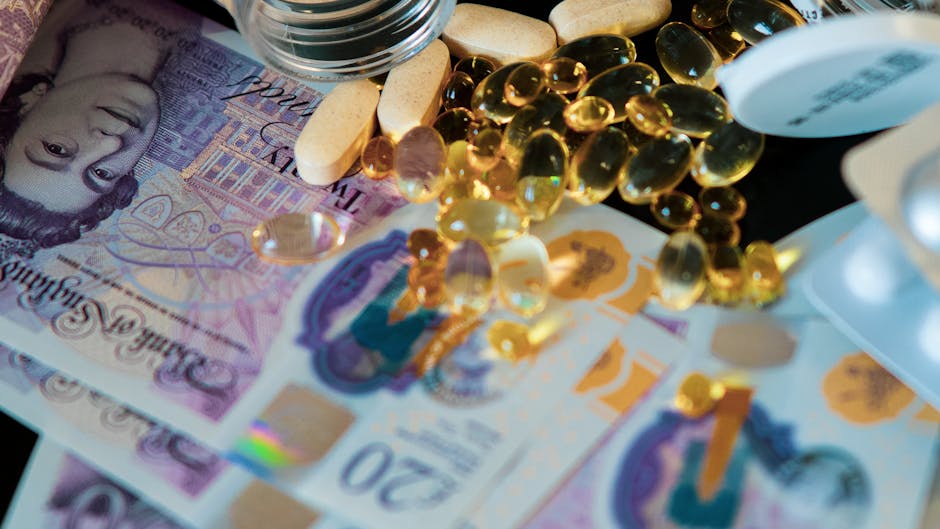 Close-up of British pound notes with pills and supplements on a black background.