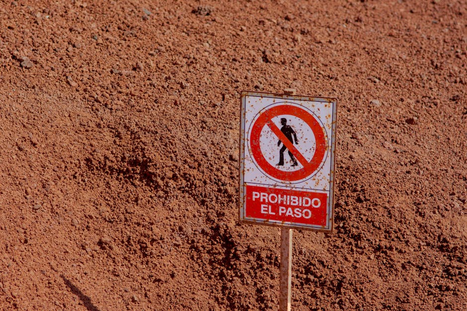 Warning sign 'Prohibido El Paso' in the arid landscape of Lanzarote, Spain. No trespassing.