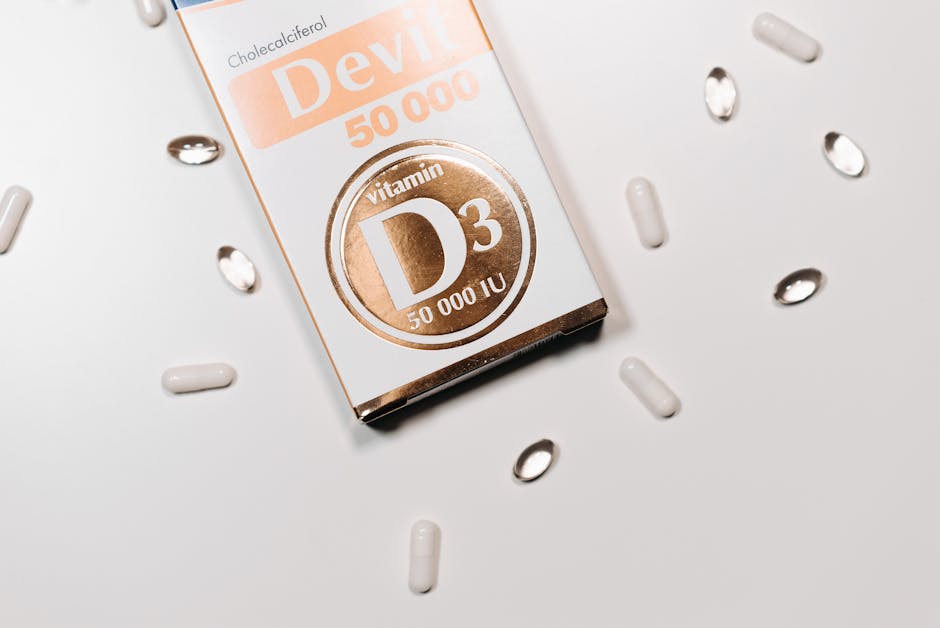 Flat lay of Vitamin D3 supplement box and capsules on a light background.