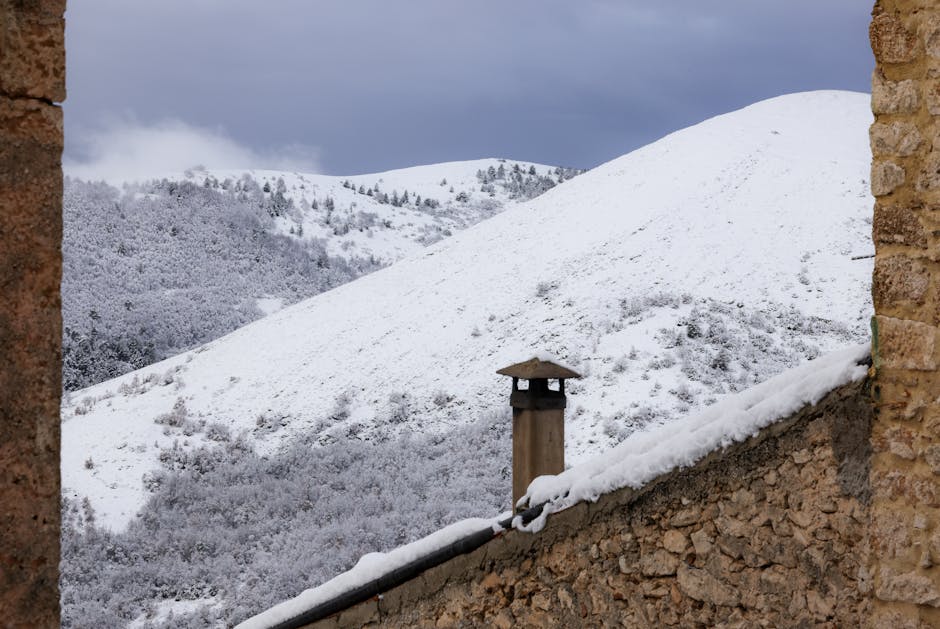 Charming winter scene of a snow-covered Italian village with mountain view.